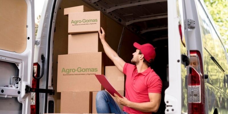 Hombre sentado en una furgoneta con cajas de Agro-Gomas Sevilla